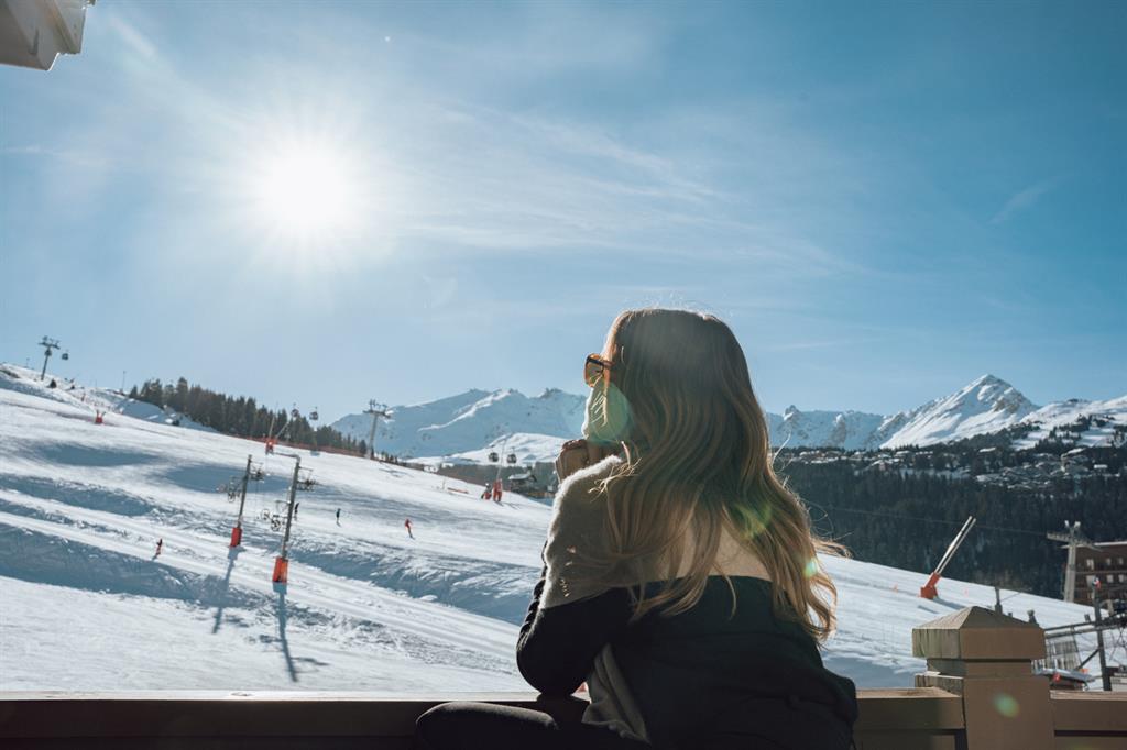 Woman on the balcony of Manali Lodge looking at the sunny mountain view 